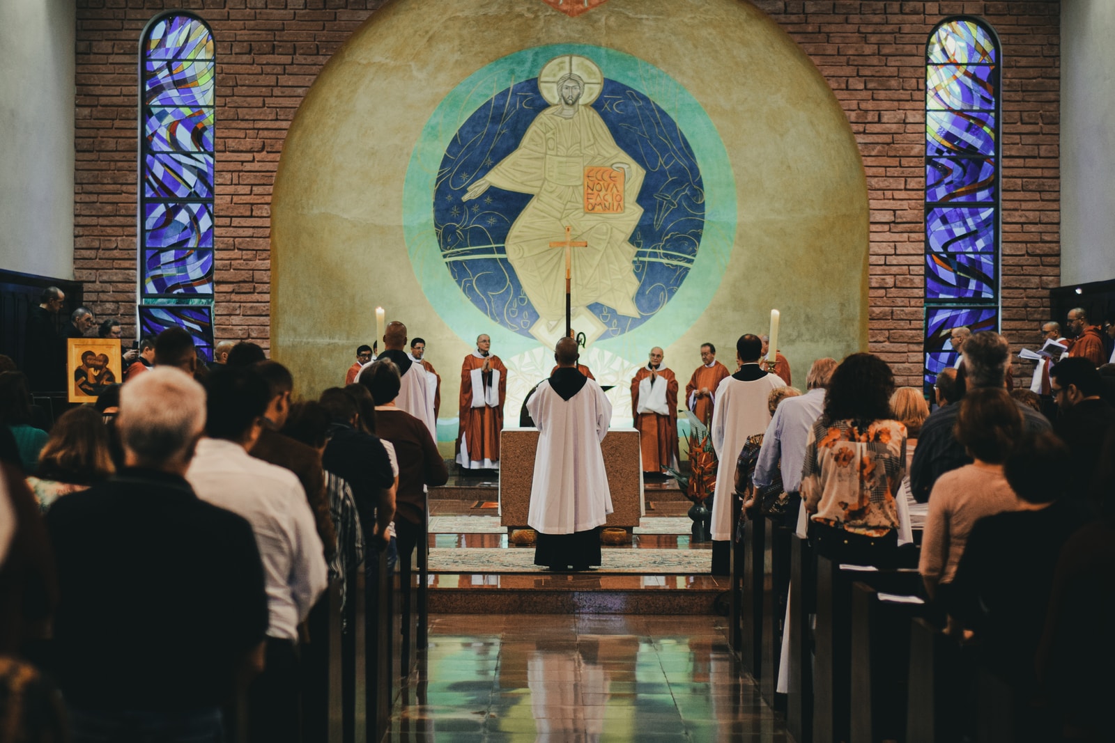 Photo by Mateus Campos Felipe priest beside people in church