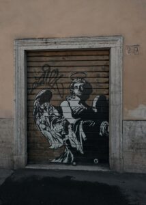 graffiti of an angel holding a baby in black and white on a garage door