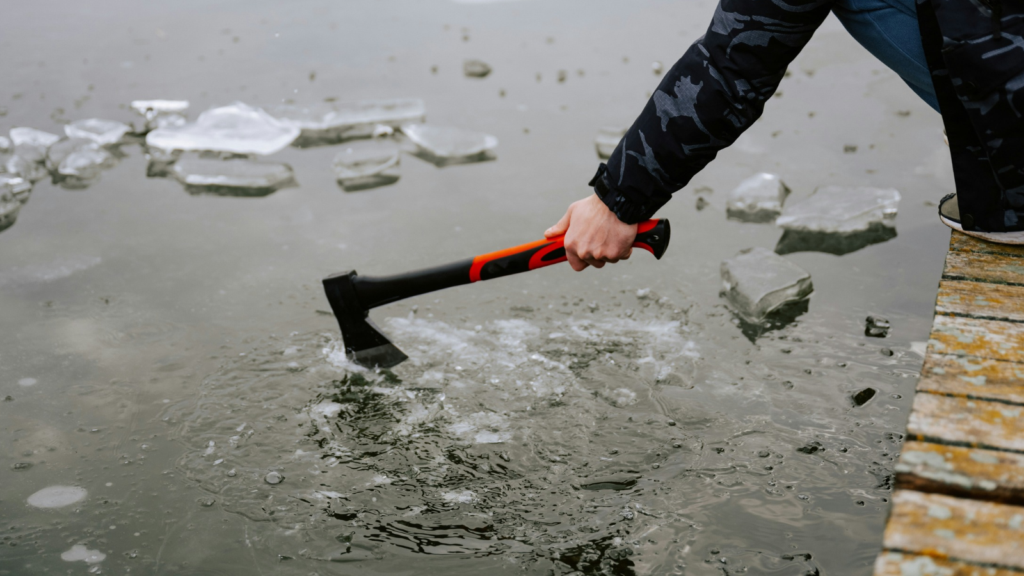 photo of someone breaking ice with an ax