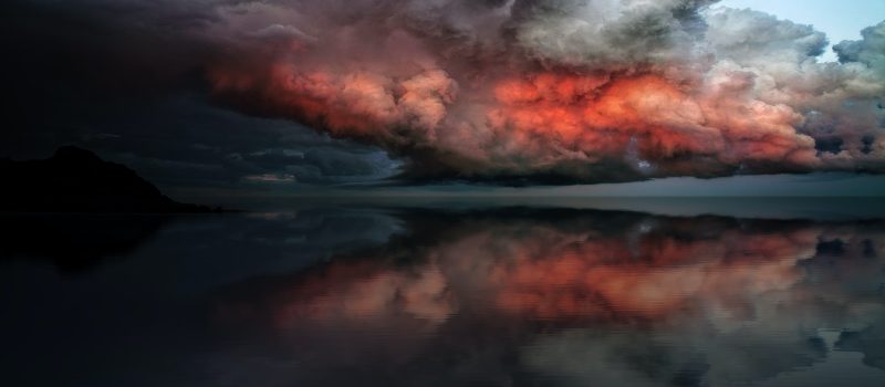 body of water under red and white clouds