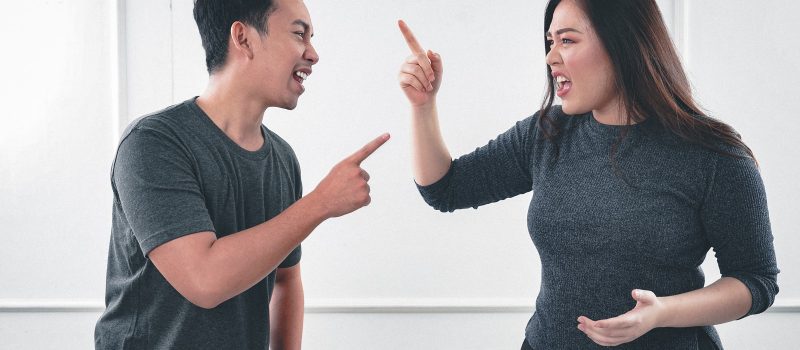 man in gray crew neck long sleeve shirt standing beside woman in black crew neck shirt